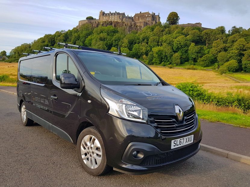 TDS Bespoke Van A grey-brown van is parked on the side of the road in front of the Stirling Castle.