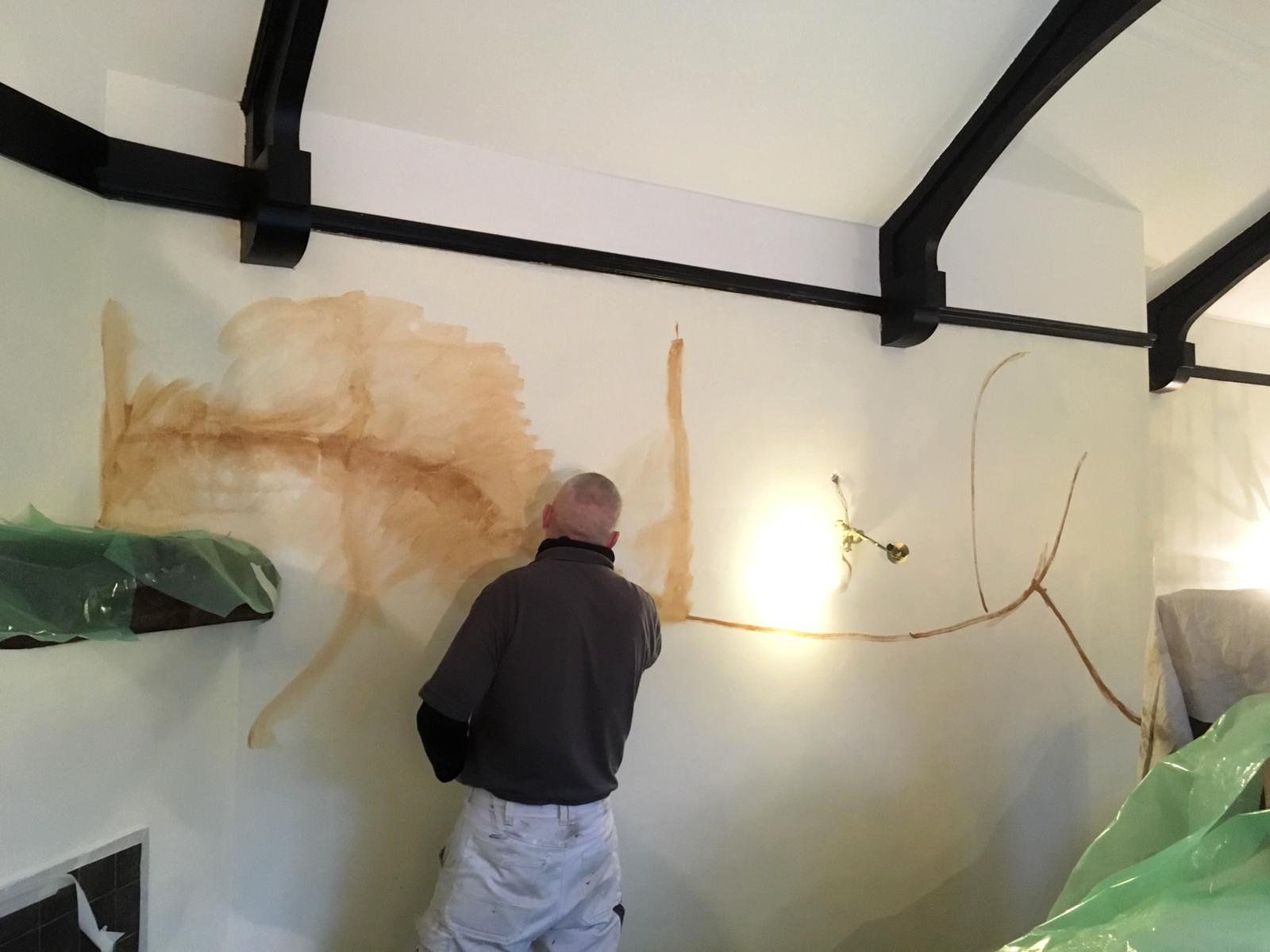 A man is painting a wall in a room.