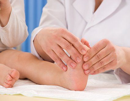 Doctor carefully examines the kid foot for any damage