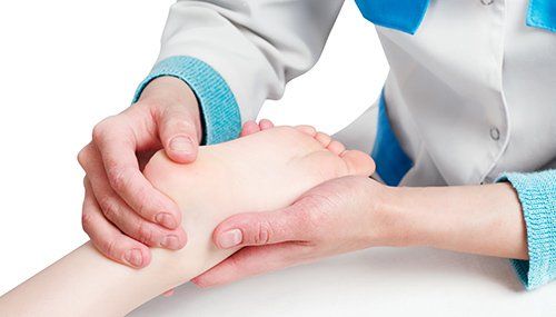 Doctor diagnosing the foot injury of the kid