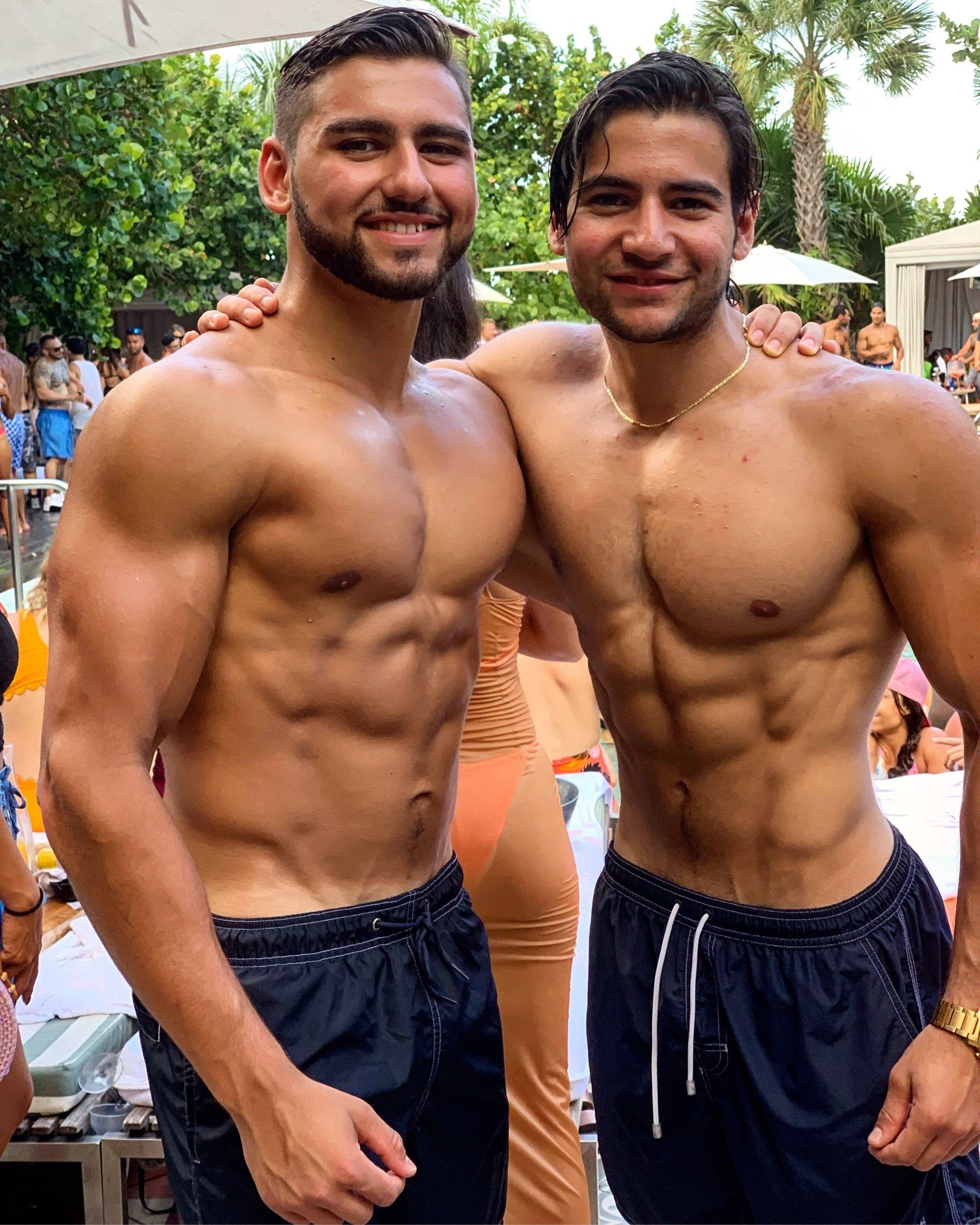 Two shirtless men are posing for a picture together.