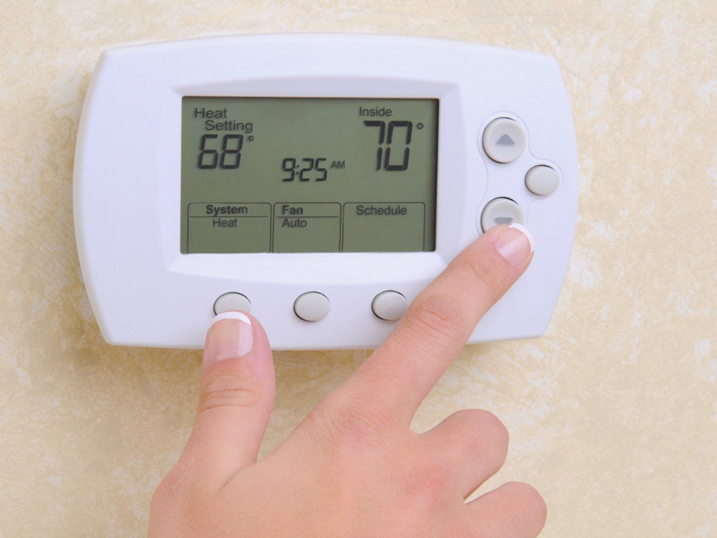 woman's hand and a digital controller for heater