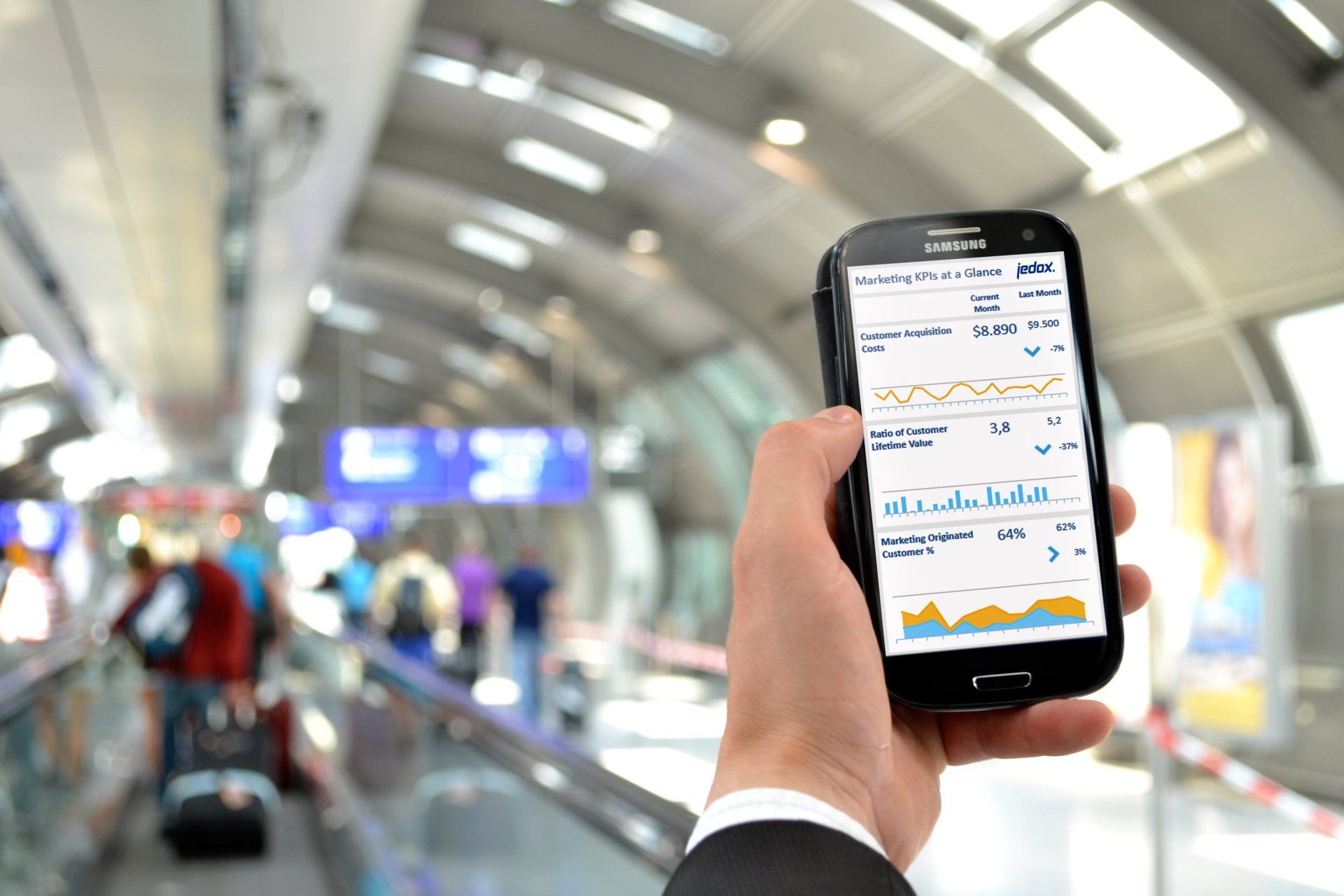 A person is holding a cell phone in their hand in an airport.
