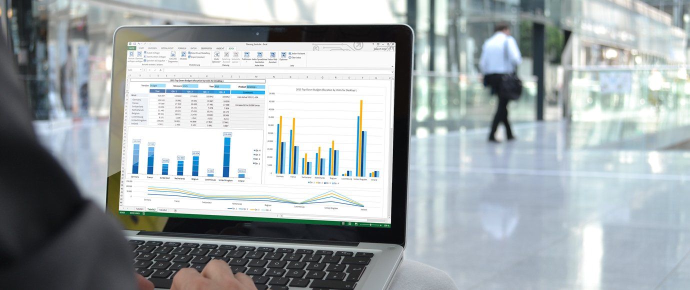 A person is using a laptop computer with a graph on the screen.