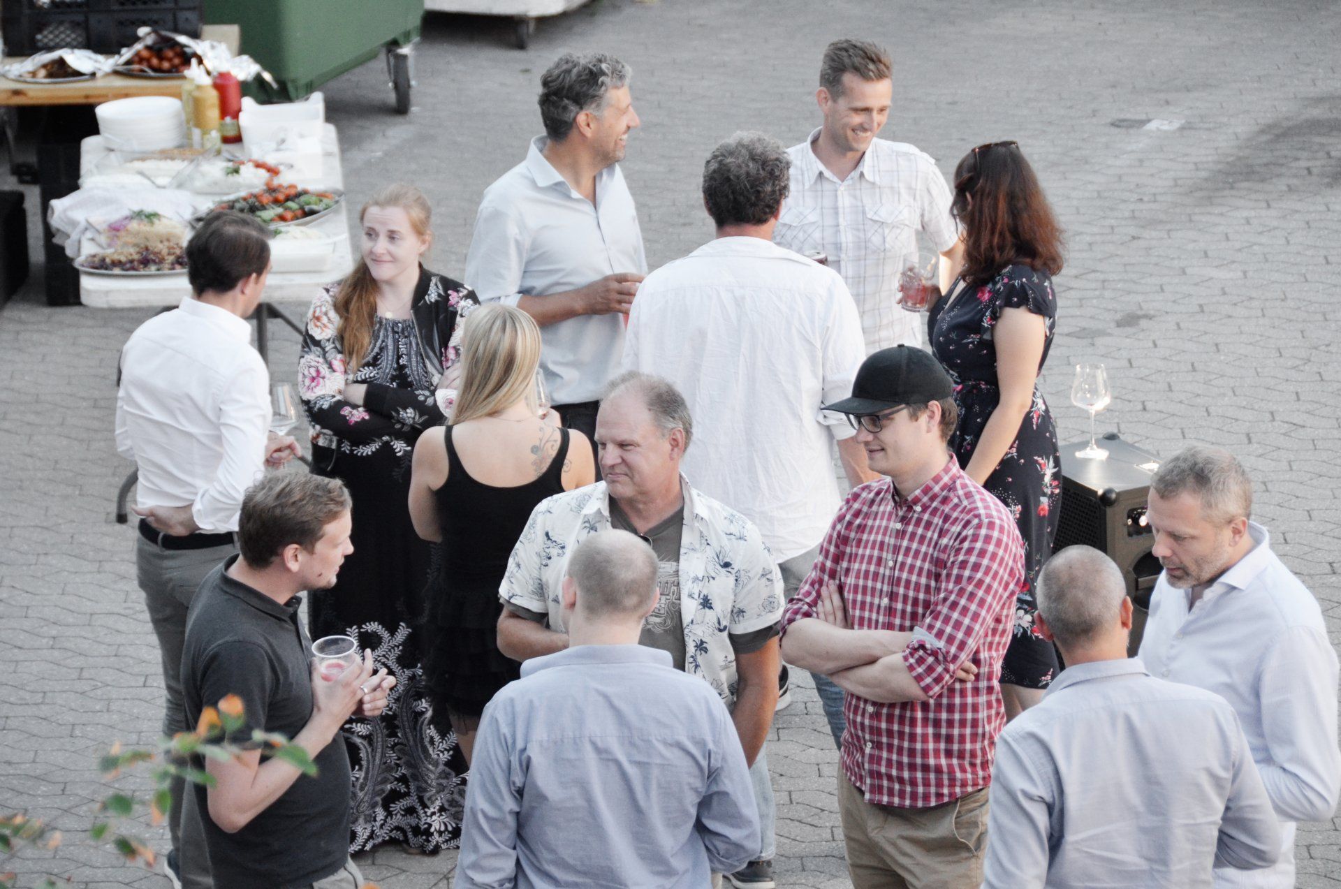 A group of people are standing in a circle talking to each other.