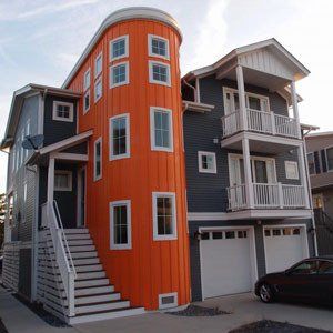 Orange and gray multi-story house with garage and exterior stairs.