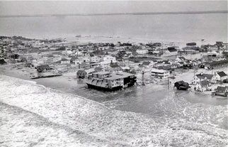 Coastal town flooded by ocean waves, buildings submerged.