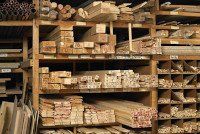 Wooden shelves stocked with lumber in a hardware store.