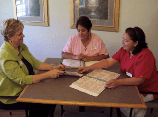 Three staff members sitting around a table. Three staff members sitting around a table.