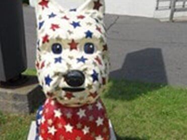 Senior couple with agent retirement — in West Springfield, MA Dog statue painted with red, white, and blue stars.
