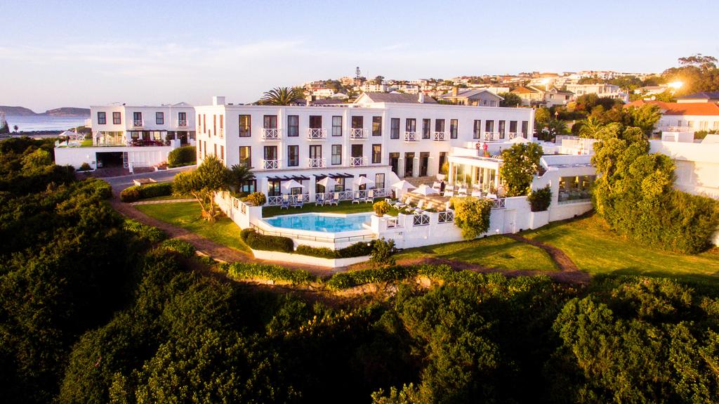 An aerial view of a large white building surrounded by trees.