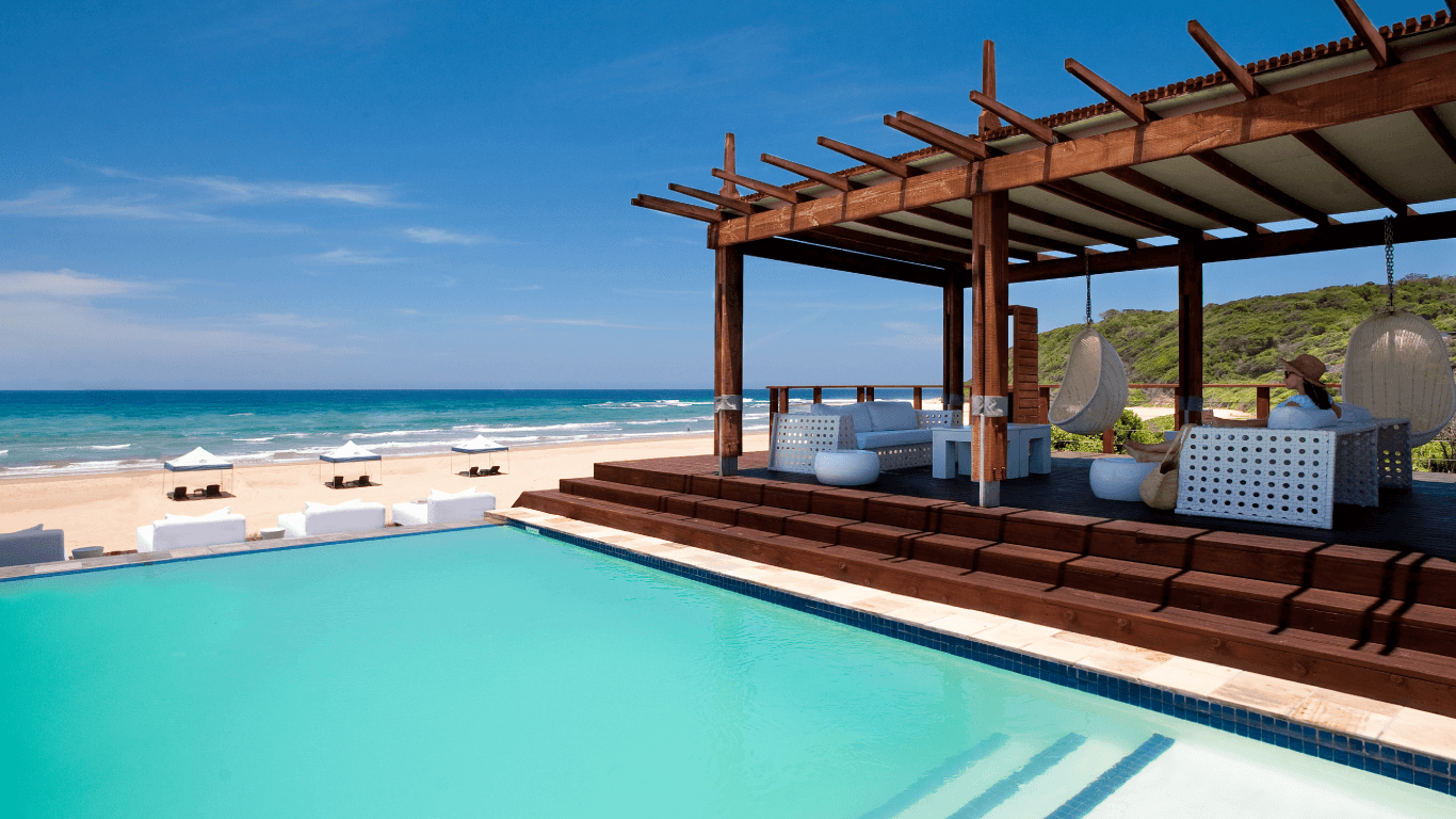 A swimming pool with a pergola overlooking the ocean