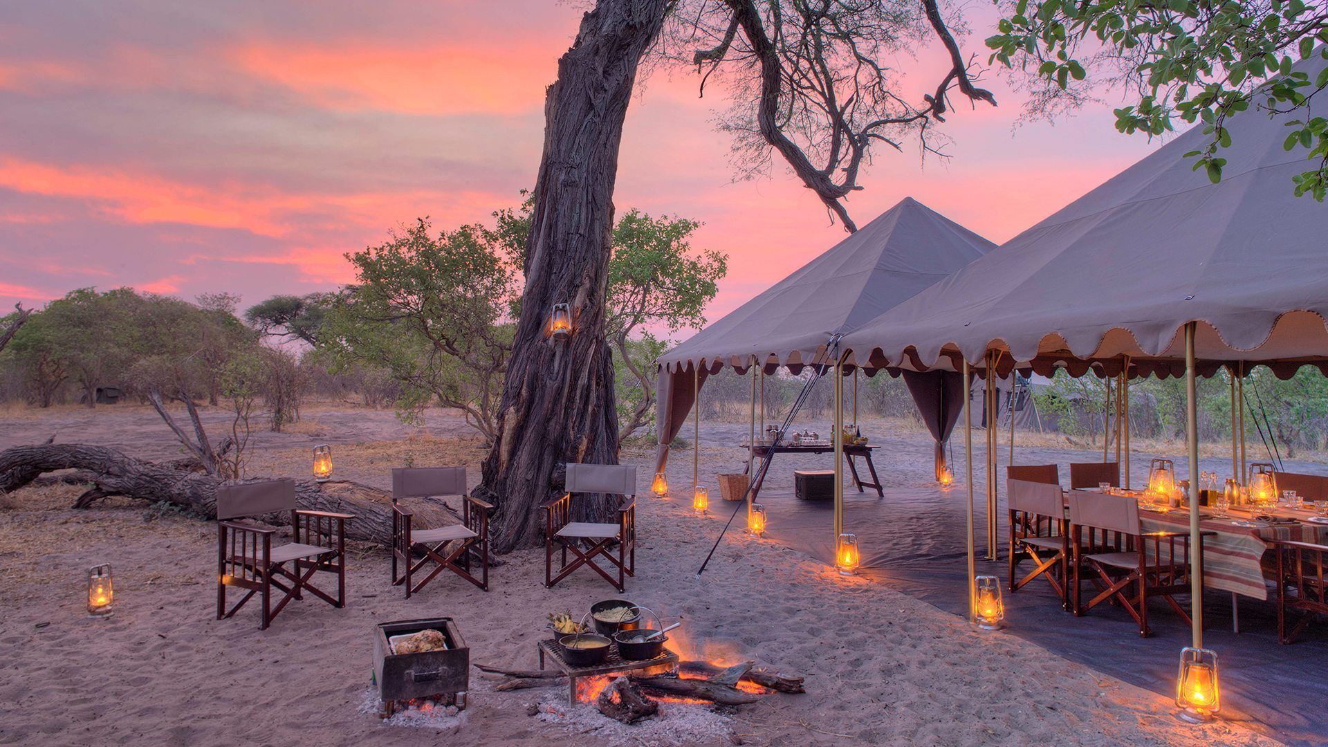 A group of tents are sitting on top of a sandy beach.