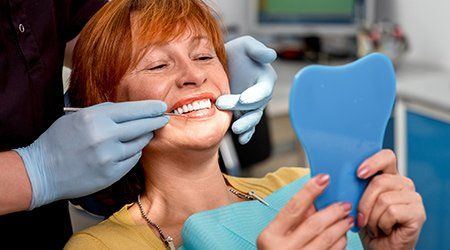 Dental And Orthodontic Treatment — Women Looking at Her Teeth in Cleveland, OH Dental And Orthodontic Treatment — Women Looking at Her Teeth in Cleveland, OH