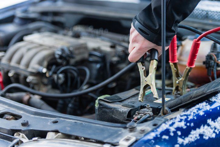 Person Fixing Vehicle Battery — Cedar Falls, IA — Rasmusson Towing Person Fixing Vehicle Battery — Cedar Falls, IA — Rasmusson Towing