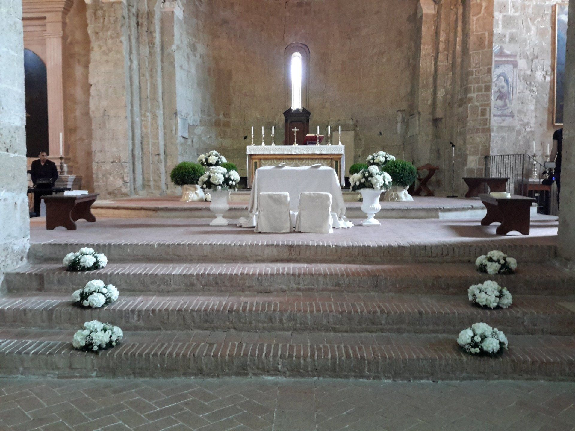 altare di una chiesa con addobbi floreali matrimoniali