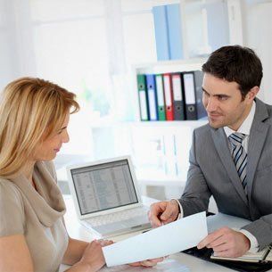 A man speaking with a woman about a document