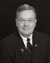 A black and white photo of a man in a suit and tie.