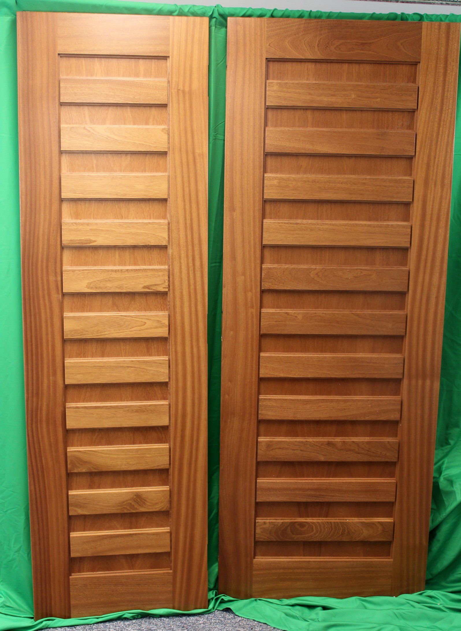 A pair of wooden doors on a green background