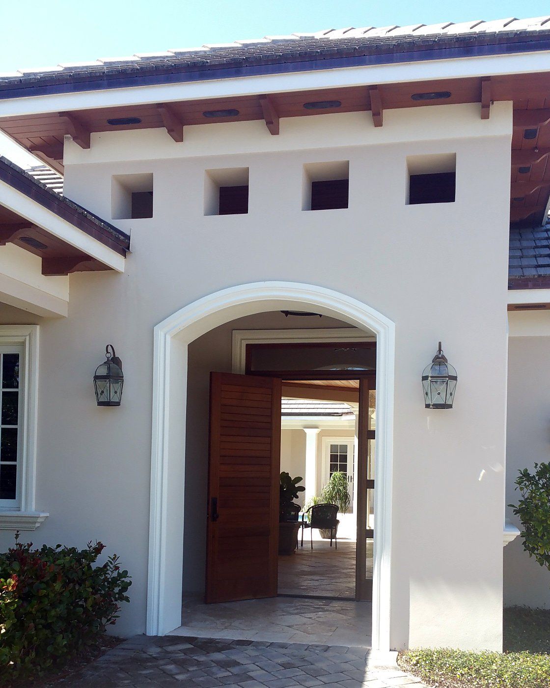 The front door of a white house with a wooden door