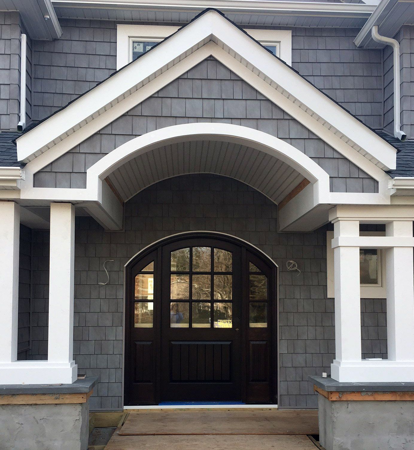 The front door of a house has a white arch over it