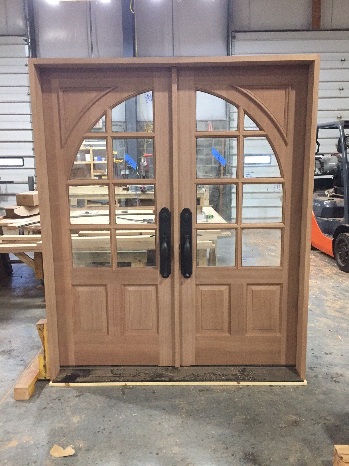 A wooden door with a forklift in the background