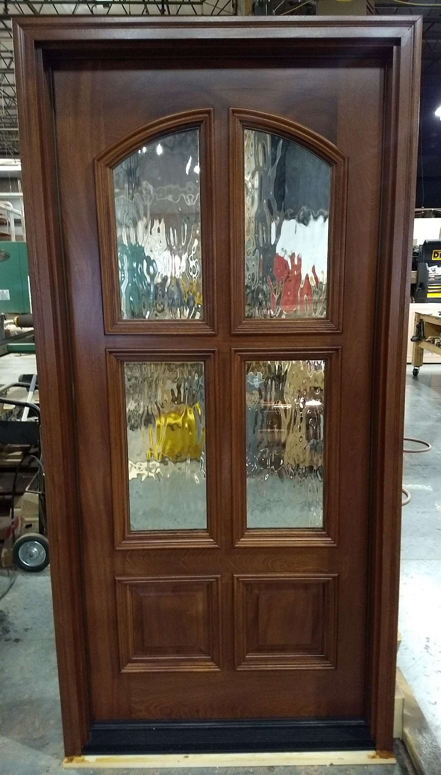 Solid wood pivot door with two glass panels stained on one side and painted on the other