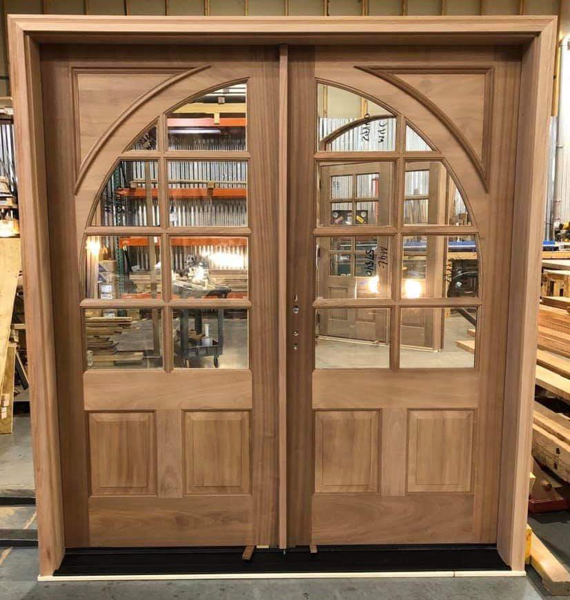 Mahogany wood double door features arched 8 lites