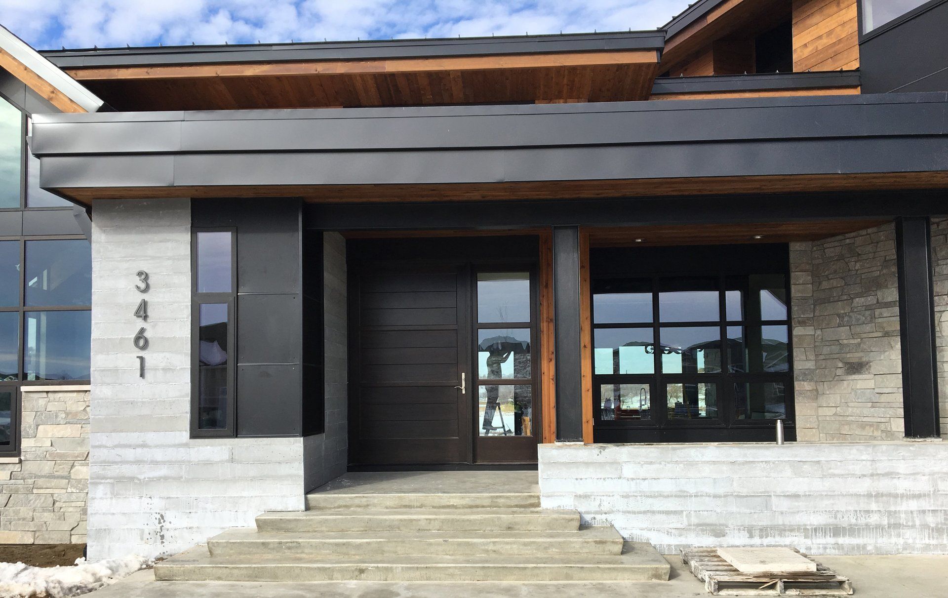 A modern house with a large front door and stairs.