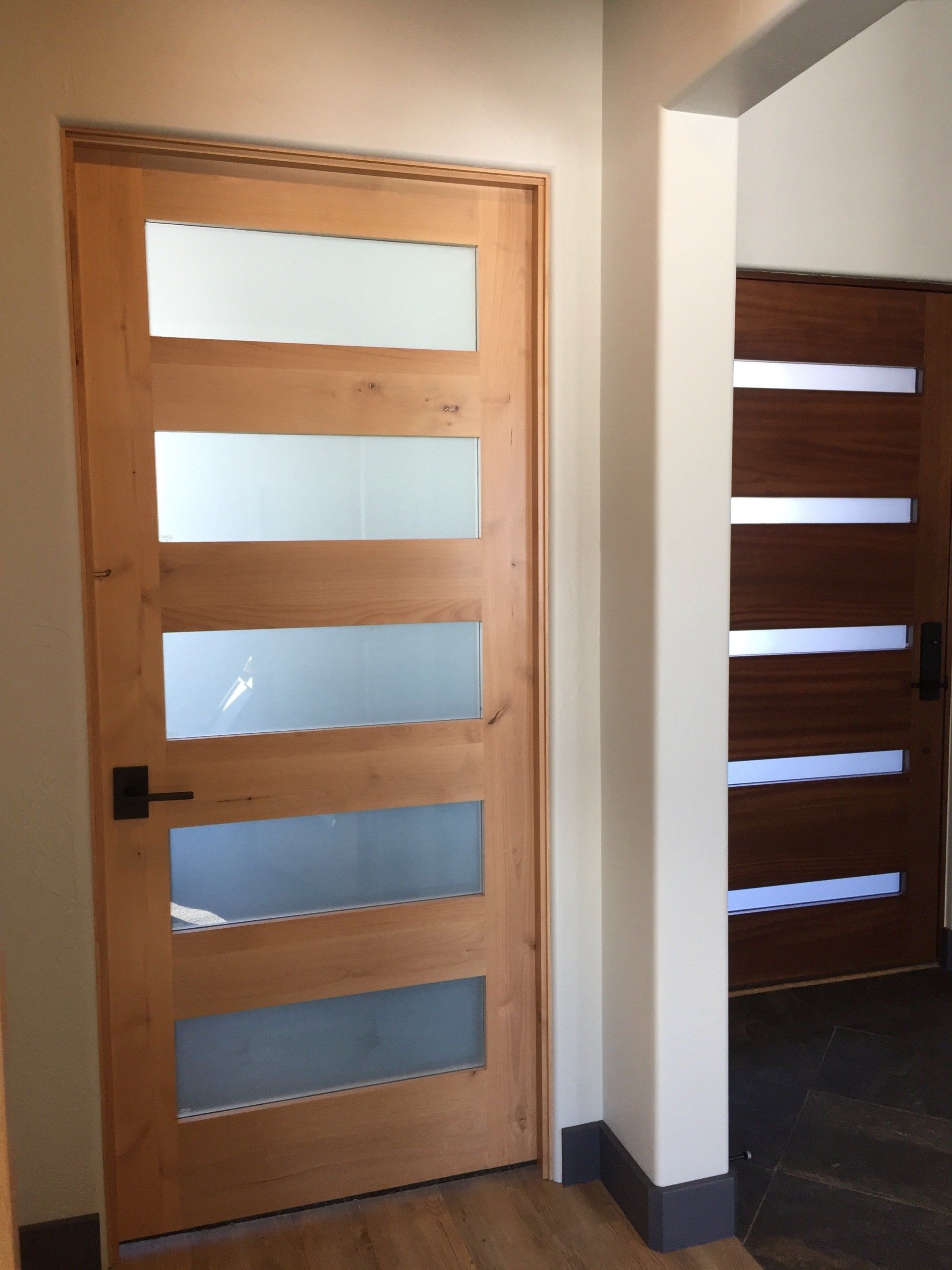 A wooden door with frosted glass panels in a hallway