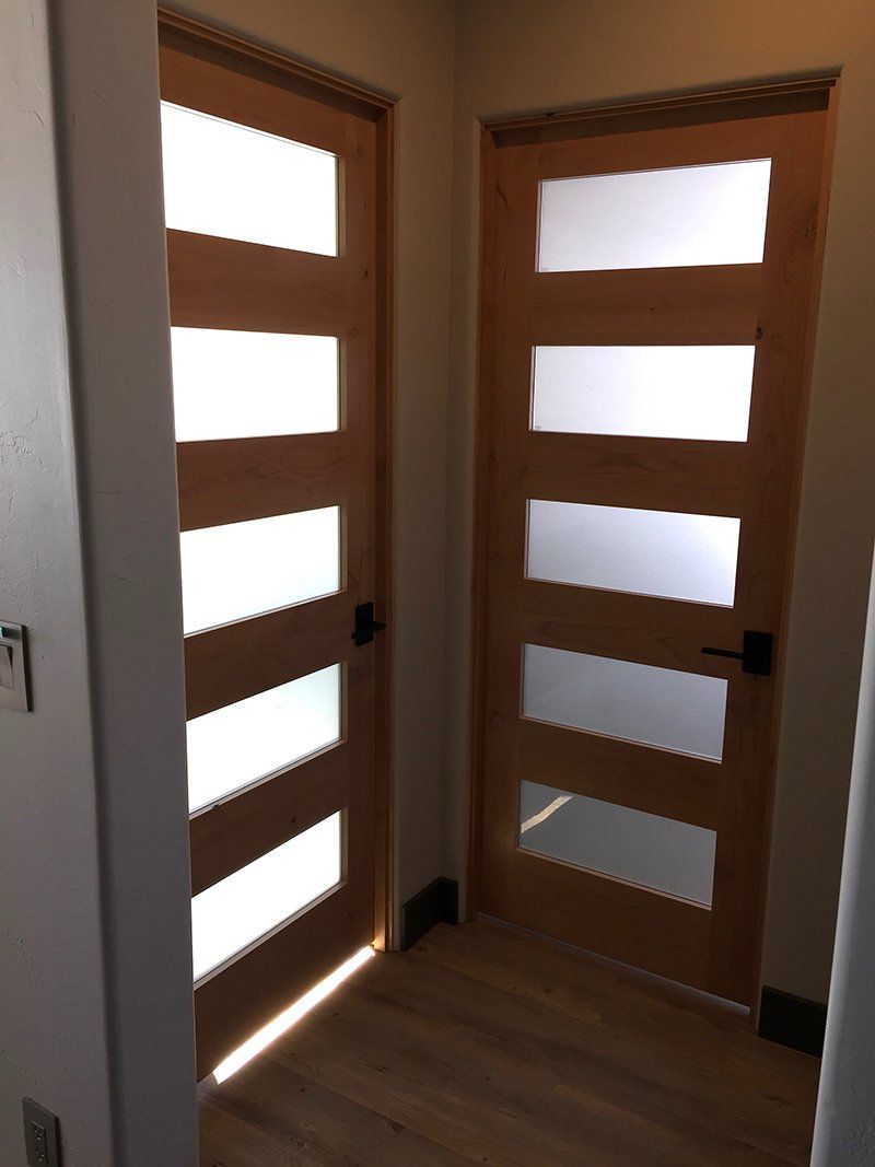 A hallway with two wooden doors with frosted glass