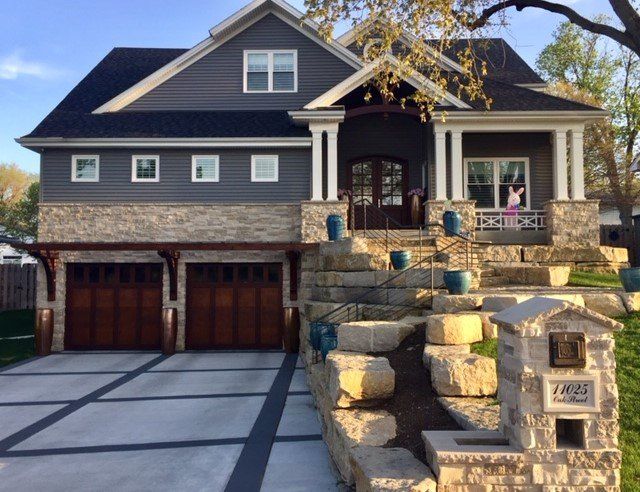 A large house with a driveway and stairs leading up to it