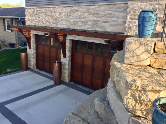 A garage with wooden doors and a stone wall