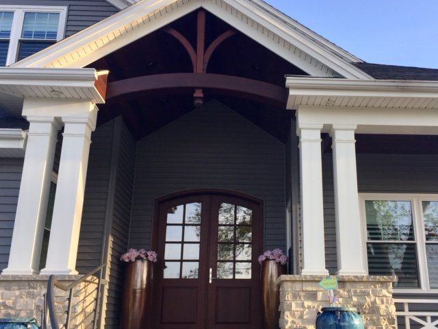 The front door of a house with a porch and columns