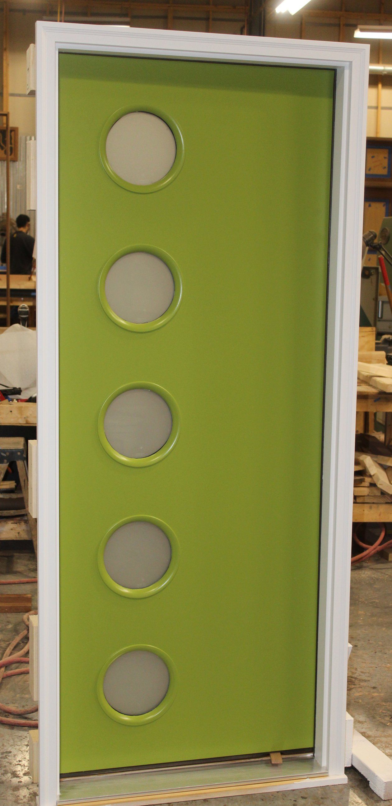 A green door with white circles on it is sitting on a table.
