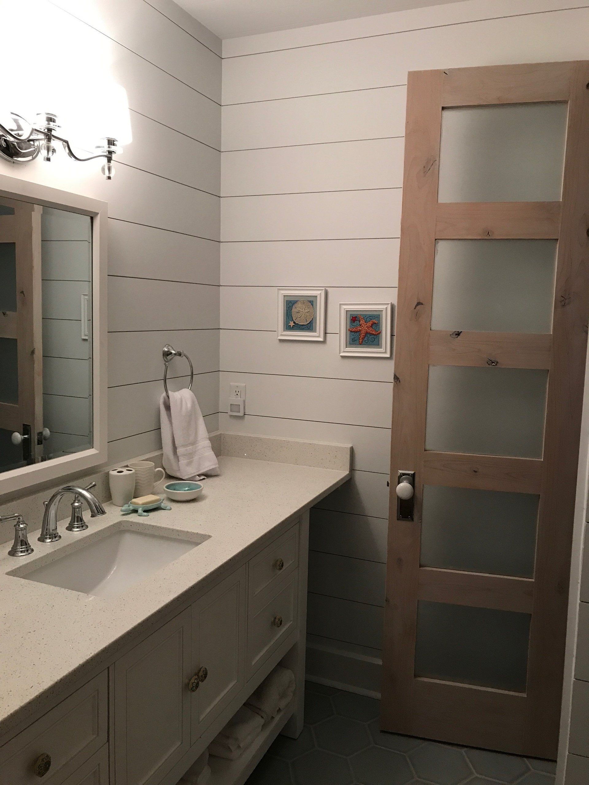 A bathroom with a sink a mirror and a door