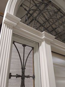 A white door with a wrought iron grille on it
