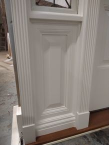 A close up of a white door with a window.