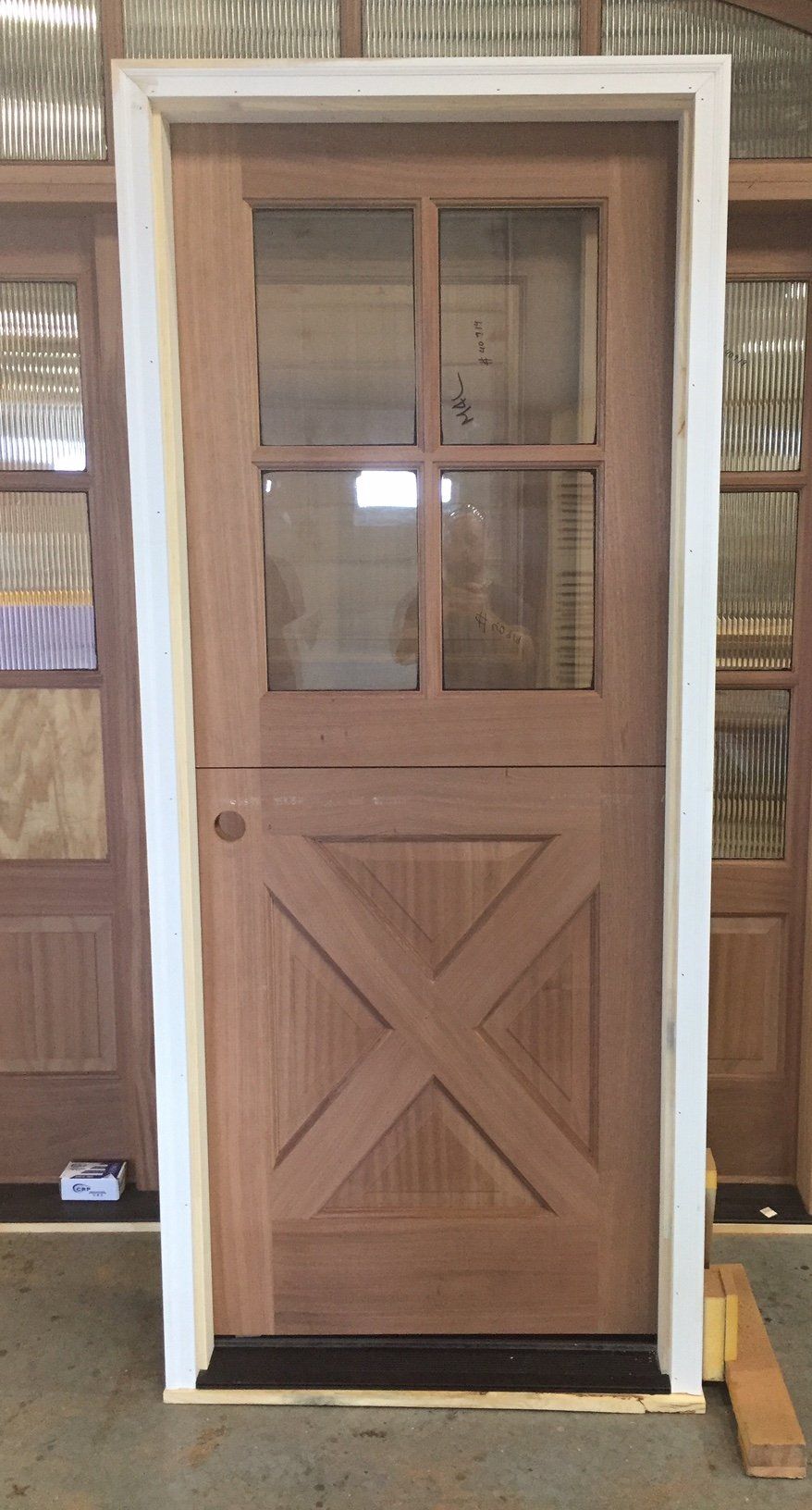 A wooden door with a cross on it is sitting on a table in a room.