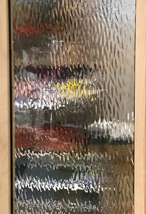 A painting is hanging on a wall in a wooden frame.