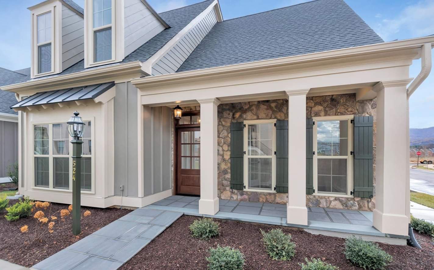 The front of a house with a porch and a walkway leading to it.