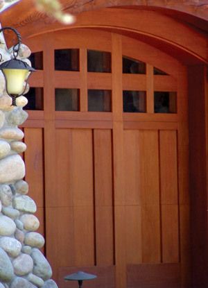 A wooden garage door with a stone wall behind it
