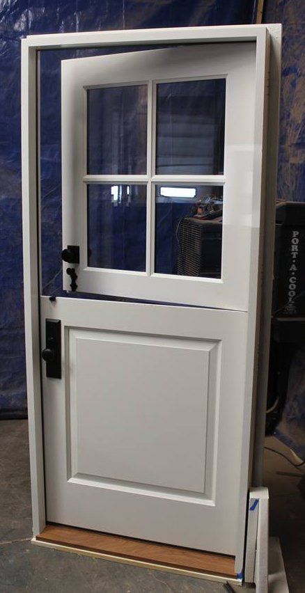 A white Dutch door with four windows and a black handle.