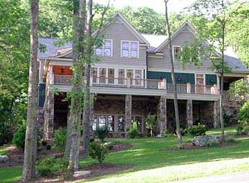 A large house with a lot of windows is surrounded by trees.