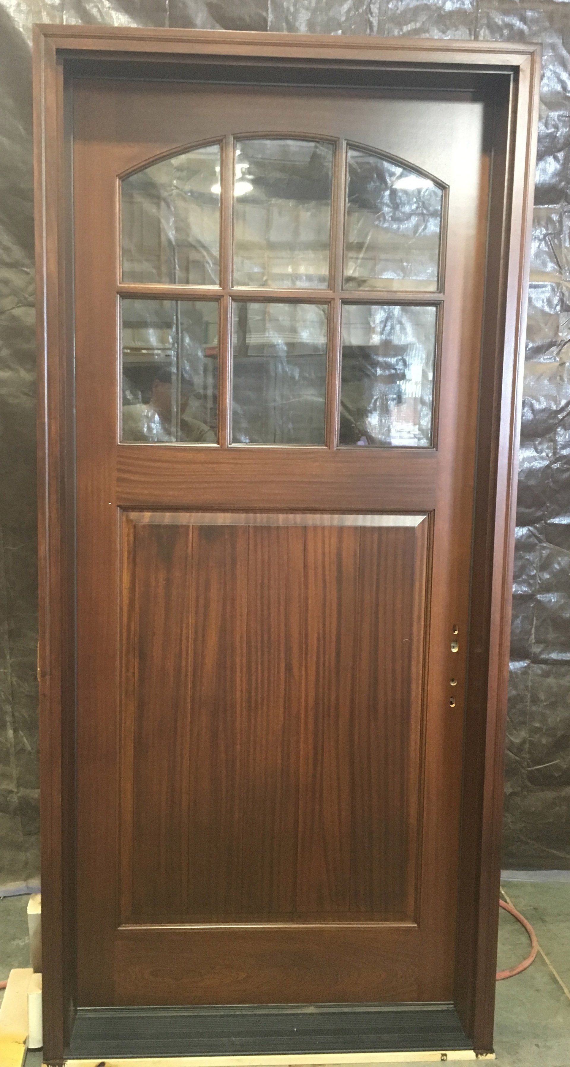 A wooden door with a glass window is sitting on a table.