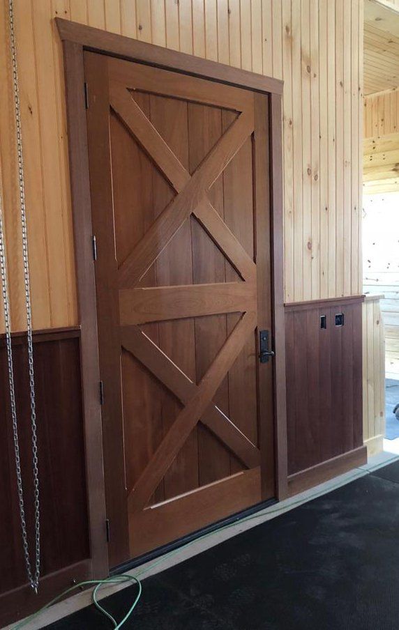 A wooden door with a cross on it is in a room.