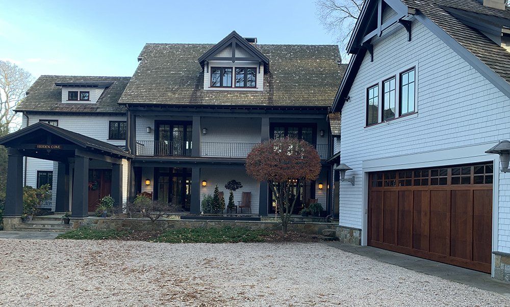 A large white house with a wooden garage door