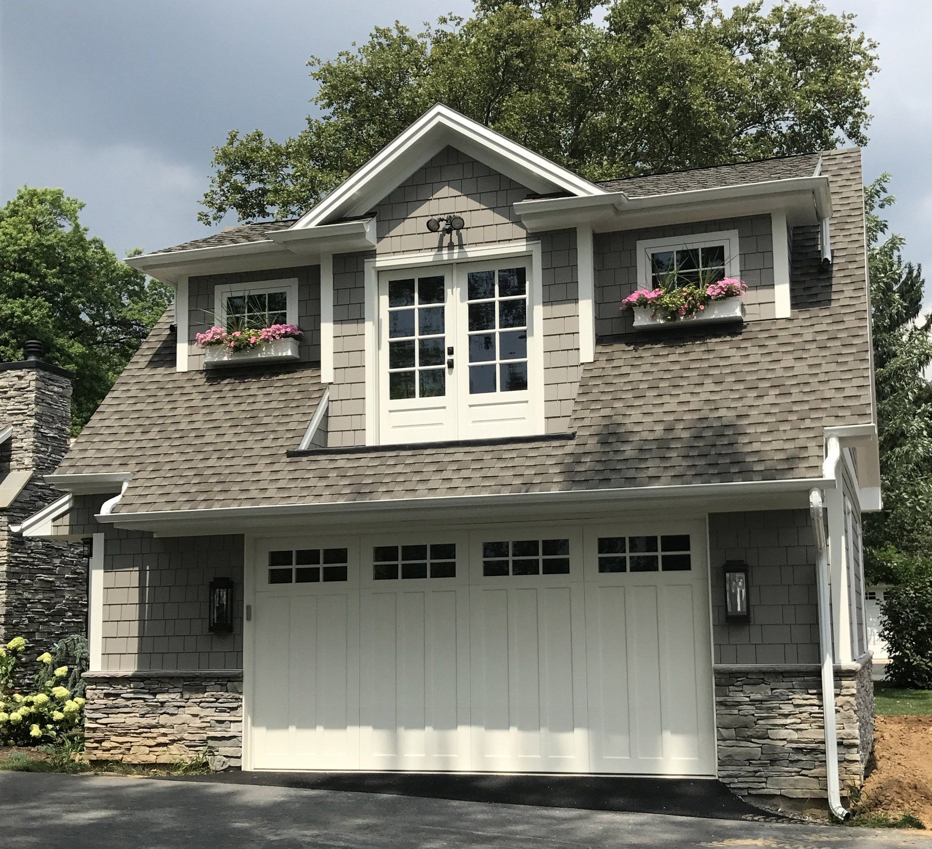 A house with a white garage door and a gray roof