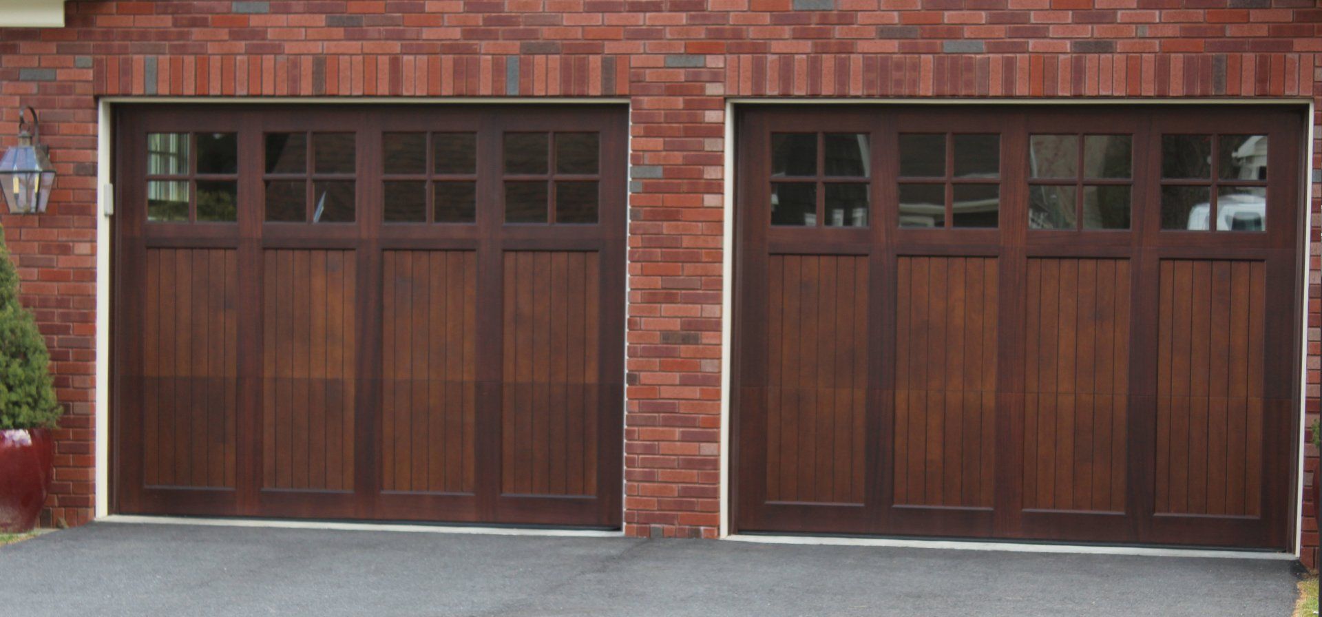 A pair of wooden garage doors on a brick building
