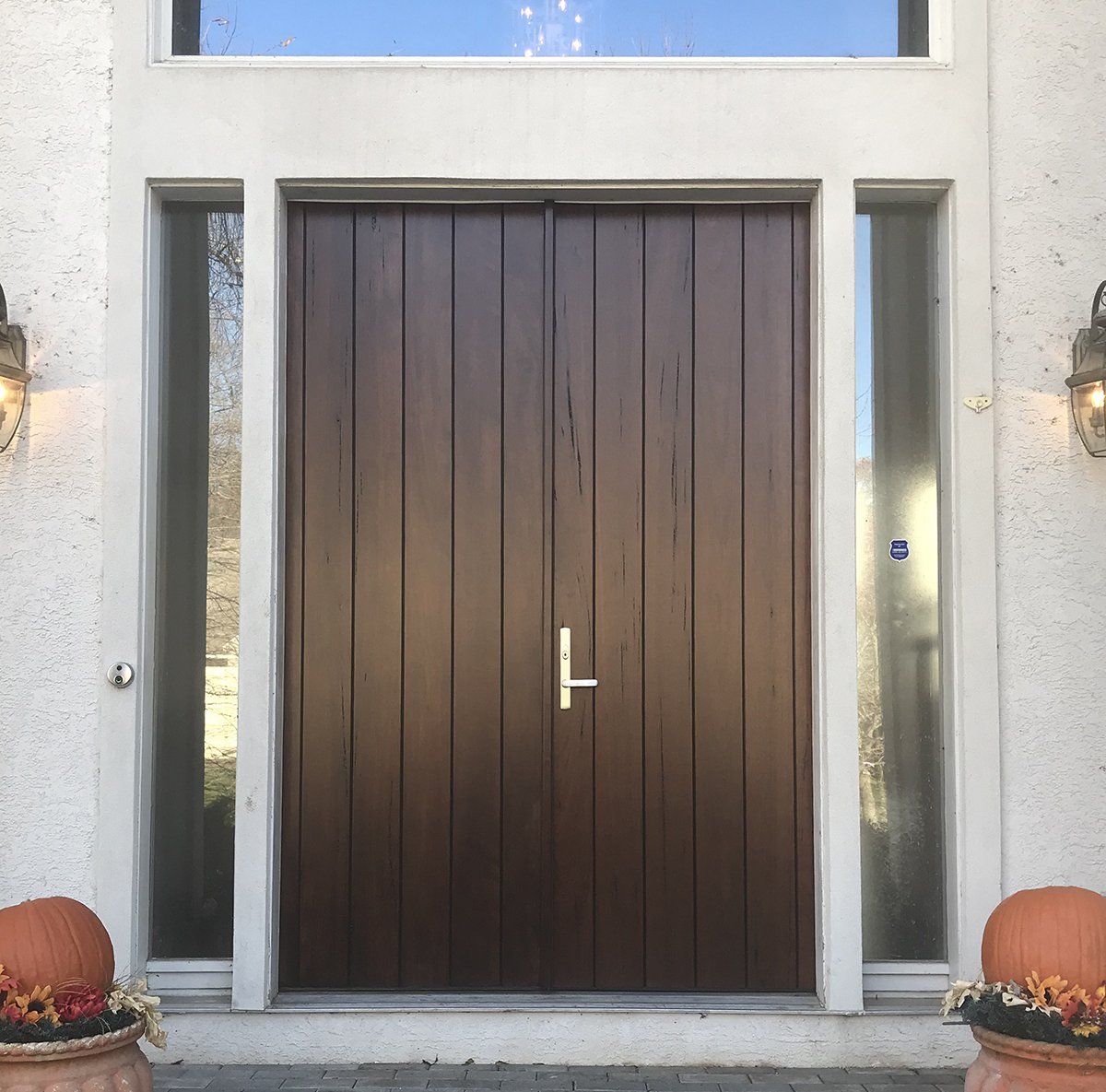 Modern double doors made from solid walnut create a visually exciting front entry